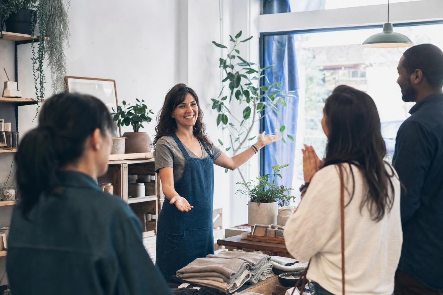 A shop owner unveiling a fresh new look to a group of delighted regular customers.