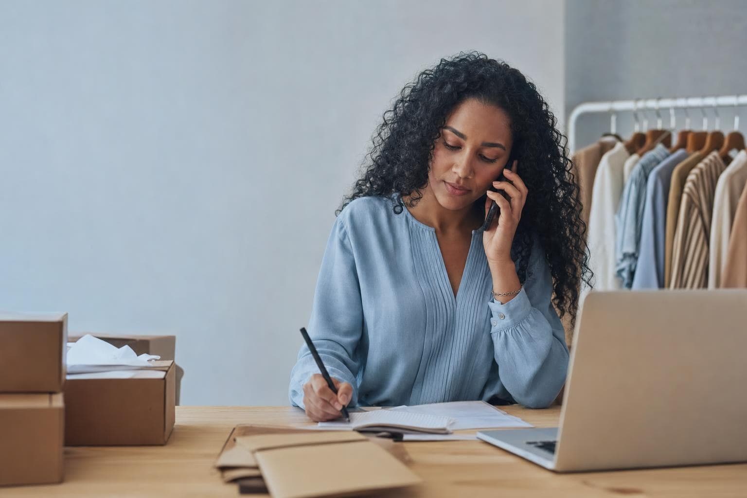 An owner on the phone with a caring expression, taking notes to make something right.