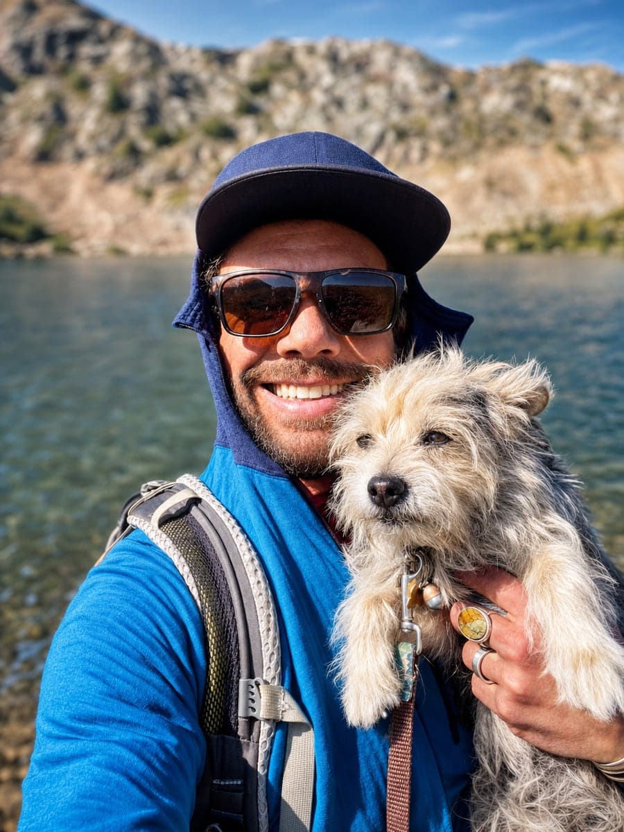 Pete holding his dog Duck beside an alpine lake