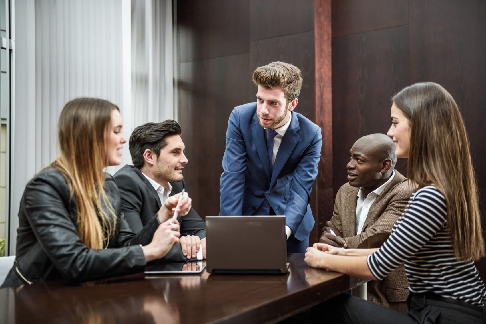 A team collaborating around a laptop